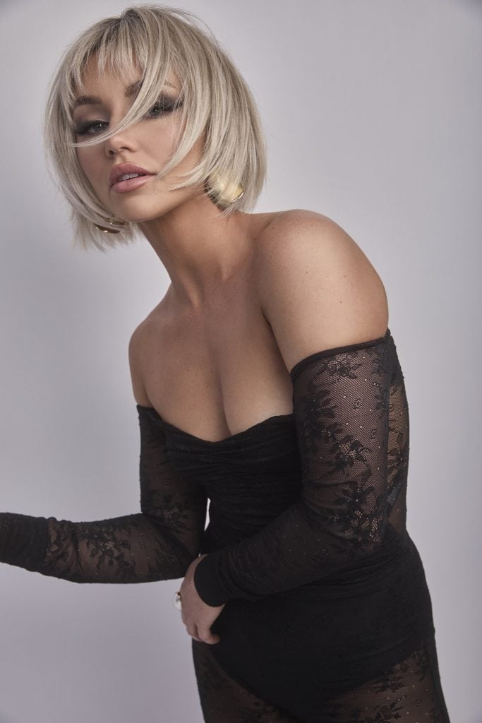 Blonde bob wig with layered style and side-swept bangs on a model.